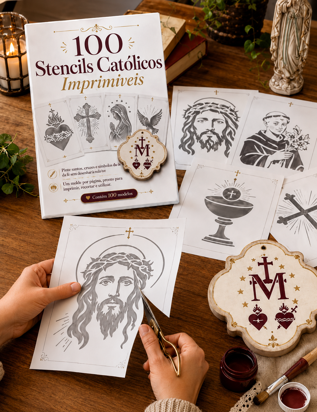 Mãos recortando um stencil católico ao lado do livro 100 Stencils Católicos Imprimíveis e diversos moldes de santos